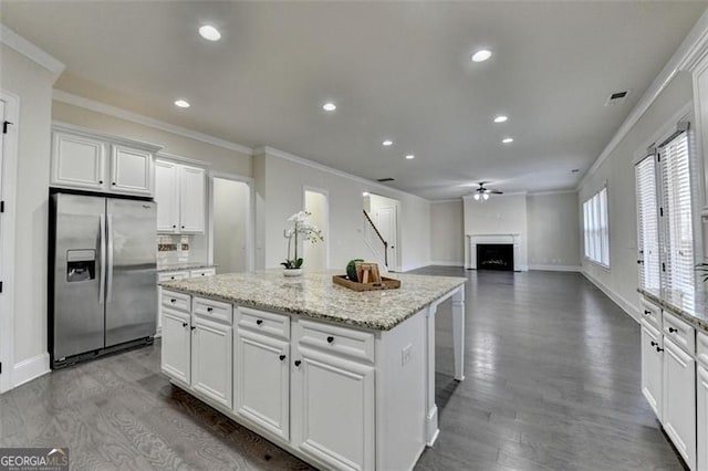 kitchen with crown molding, a center island, white cabinets, and stainless steel refrigerator with ice dispenser