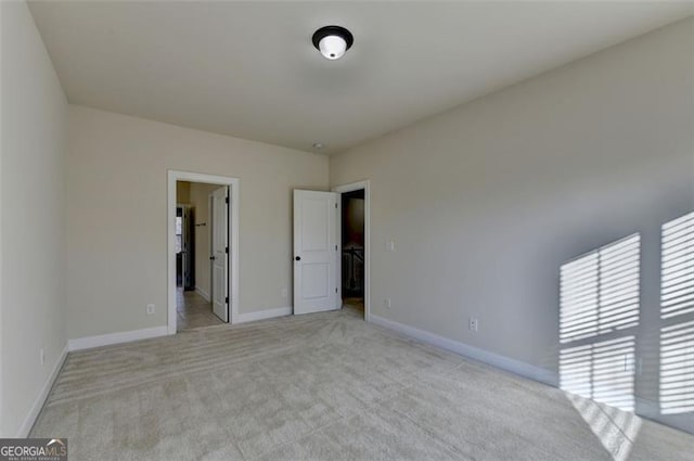 unfurnished bedroom with light colored carpet and ensuite bathroom