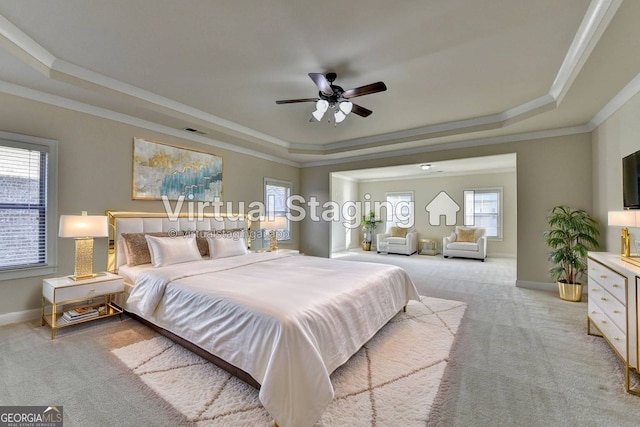 carpeted bedroom featuring ornamental molding, a raised ceiling, and ceiling fan