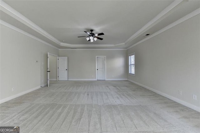 carpeted spare room featuring crown molding, a raised ceiling, and ceiling fan