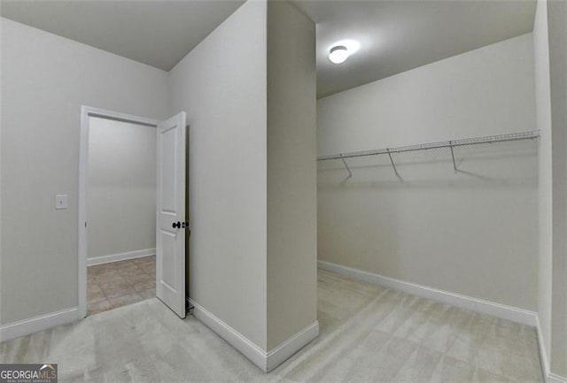 walk in closet with light colored carpet