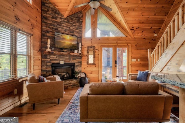 273 Deer Crest Hts, Blue Ridge, GA 30513 - living room with wood ceiling, wooden walls, a fireplace, light hardwood / wood-style floors, and french doors