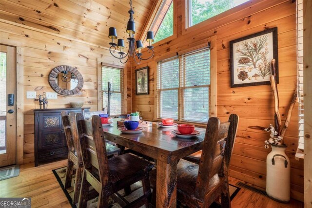 273 Deer Crest Hts, Blue Ridge, GA 30513 - dining space featuring an inviting chandelier, wooden walls, high vaulted ceiling, and light wood-type flooring