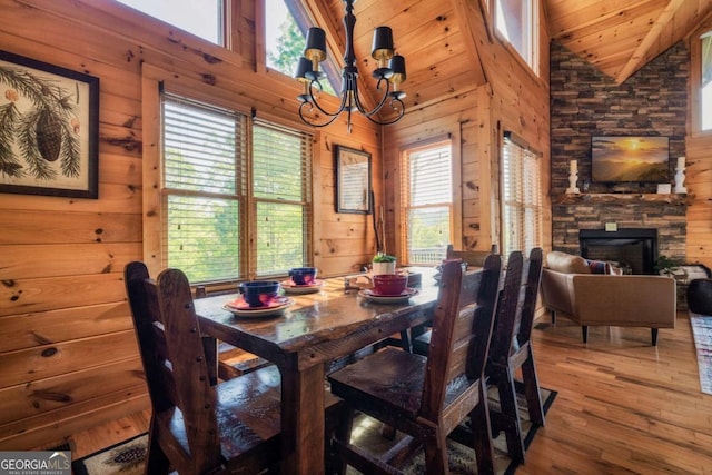273 Deer Crest Hts, Blue Ridge, GA 30513 - dining space with a stone fireplace, wooden walls, wood-type flooring, a notable chandelier, and wooden ceiling