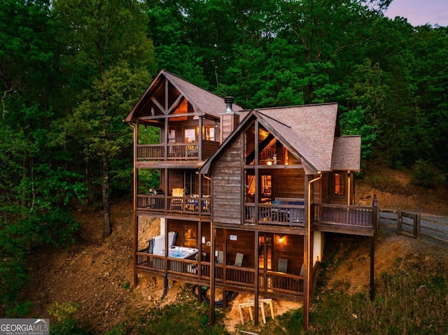 back house at dusk featuring a balcony