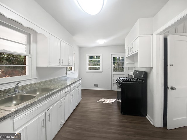 kitchen featuring white cabinetry, dark wood-type flooring, black gas stove, and sink