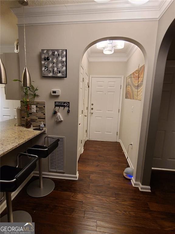 corridor featuring ornamental molding and dark hardwood / wood-style floors