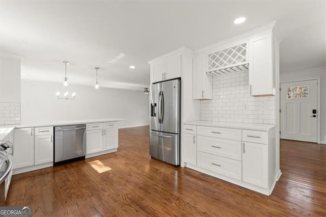 kitchen featuring stainless steel appliances, white cabinets, dark hardwood / wood-style flooring, and decorative light fixtures