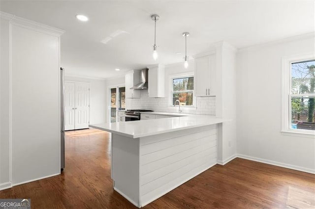 kitchen featuring white cabinetry, stainless steel range, kitchen peninsula, and wall chimney range hood