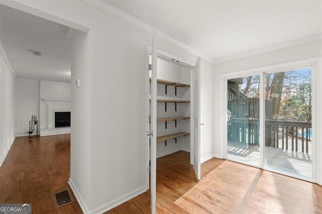 doorway to outside featuring crown molding and wood-type flooring