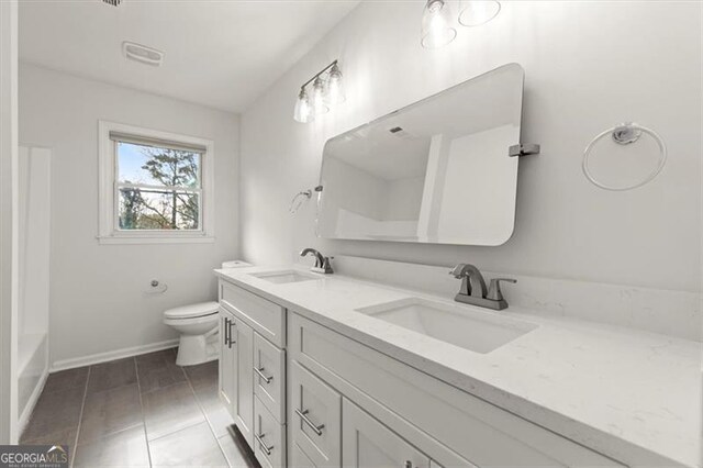 bathroom featuring tile patterned floors, vanity, and toilet