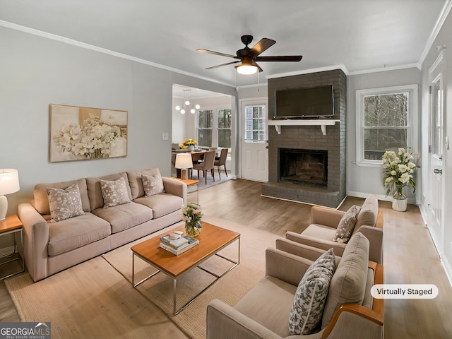 living room with crown molding, a brick fireplace, ceiling fan, and light hardwood / wood-style flooring