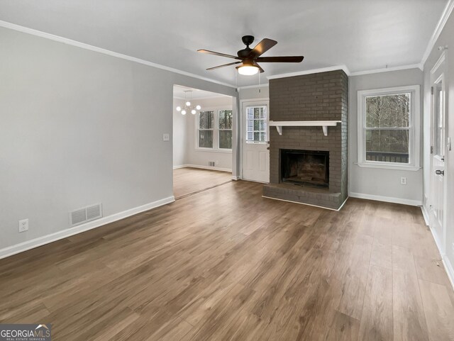 unfurnished living room featuring crown molding, a fireplace, ceiling fan, and hardwood / wood-style flooring