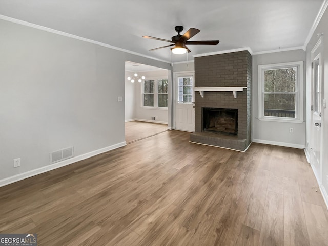 unfurnished living room with ceiling fan, ornamental molding, a fireplace, and wood-type flooring