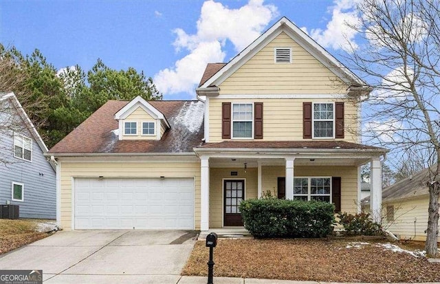 front facade with a garage, central AC unit, and covered porch