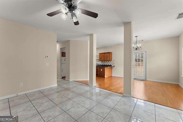 spare room with light tile patterned floors and ceiling fan with notable chandelier