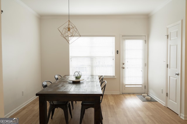 dining room with ornamental molding and light wood-type flooring