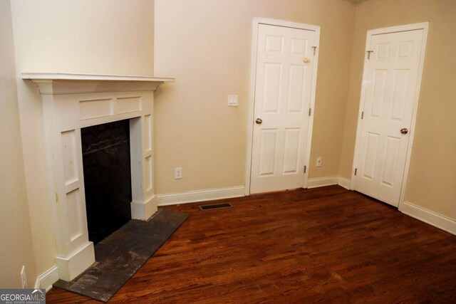 unfurnished living room featuring dark hardwood / wood-style floors and a high end fireplace