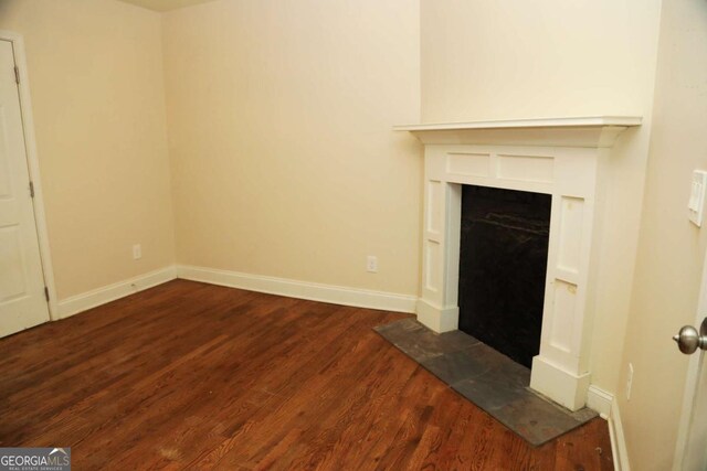 unfurnished living room with dark hardwood / wood-style flooring