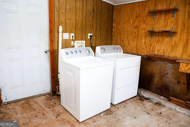 laundry area featuring wooden walls and independent washer and dryer