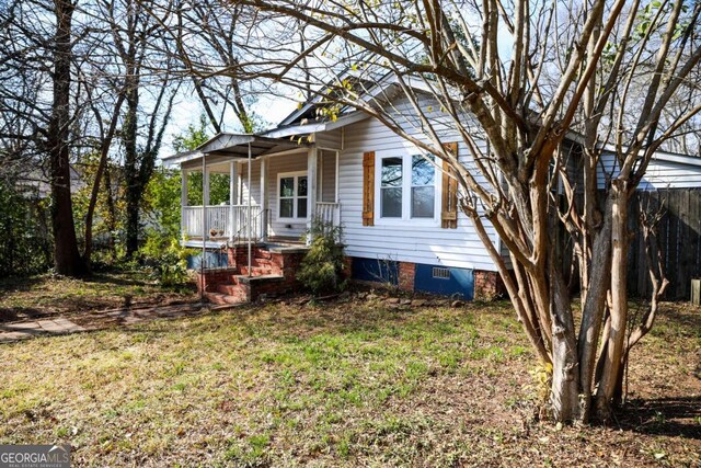 view of front of property with a porch and a front lawn