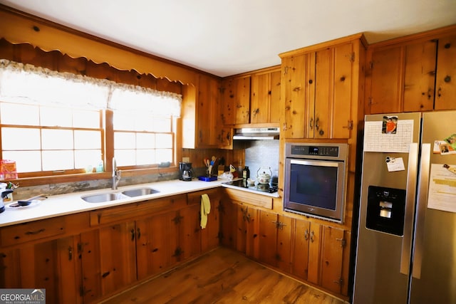 kitchen featuring appliances with stainless steel finishes, sink, and hardwood / wood-style floors