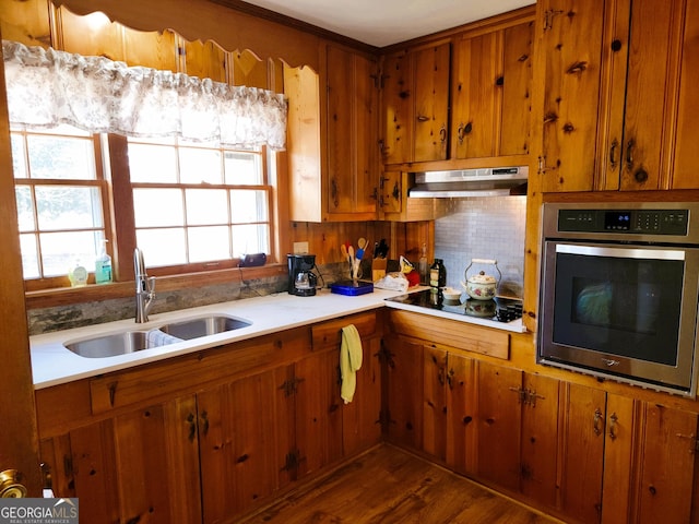 kitchen featuring dark hardwood / wood-style floors, sink, oven, backsplash, and black electric stovetop