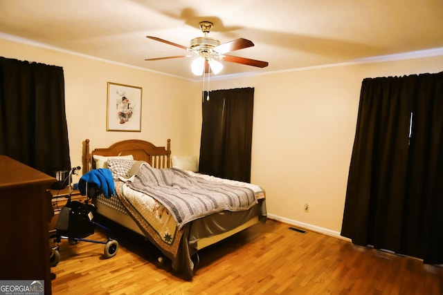 bedroom featuring ceiling fan, ornamental molding, and hardwood / wood-style floors