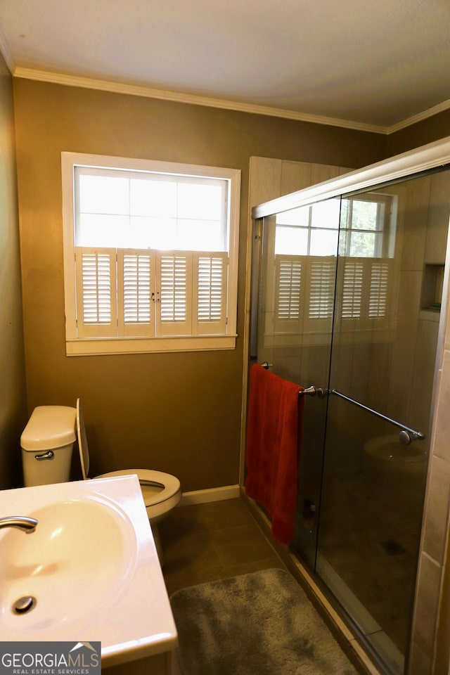 bathroom with crown molding, plenty of natural light, a shower with shower door, and toilet