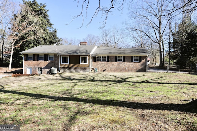 rear view of house with a yard and central AC unit