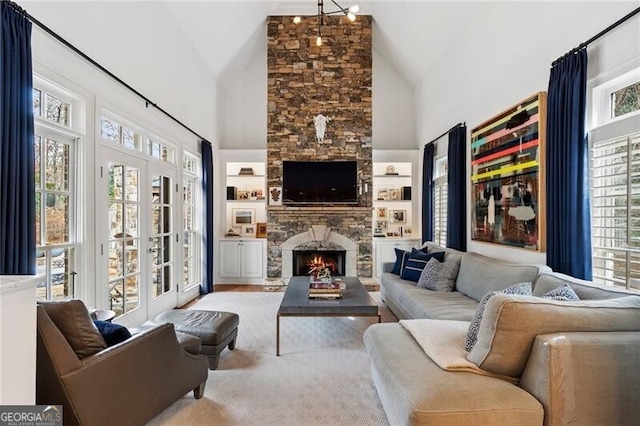 living room with a fireplace, a wealth of natural light, and high vaulted ceiling