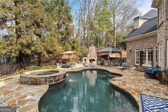 view of swimming pool with an in ground hot tub, a gazebo, a patio, and an outdoor stone fireplace