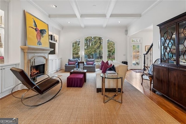 sitting room featuring beam ceiling, ornamental molding, coffered ceiling, and light hardwood / wood-style floors