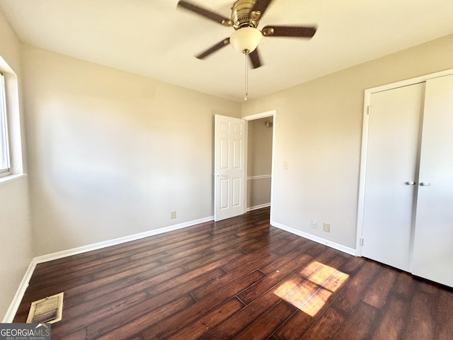 unfurnished bedroom featuring ceiling fan, dark hardwood / wood-style flooring, and a closet