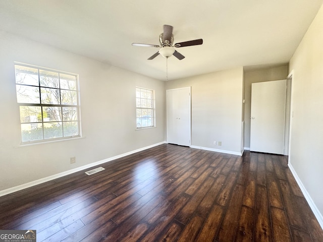 empty room with dark hardwood / wood-style floors and ceiling fan