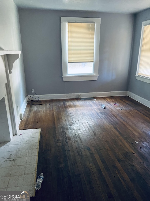 unfurnished room featuring dark hardwood / wood-style floors and a wealth of natural light