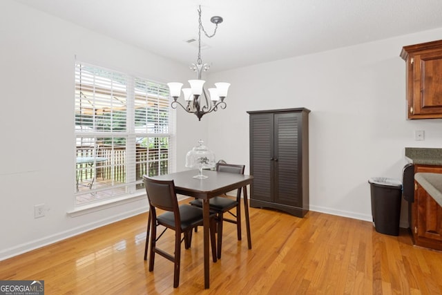 dining area featuring an inviting chandelier and light hardwood / wood-style floors