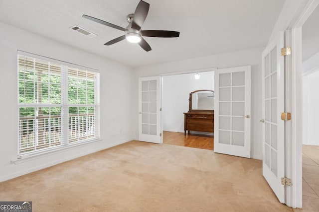 interior space featuring light colored carpet, ceiling fan, and french doors