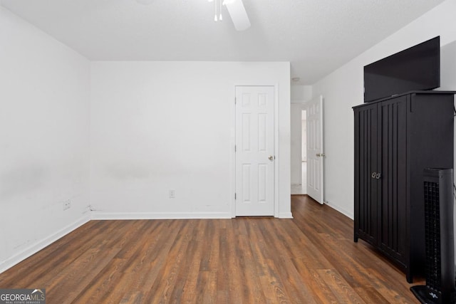 unfurnished bedroom with dark hardwood / wood-style floors and ceiling fan