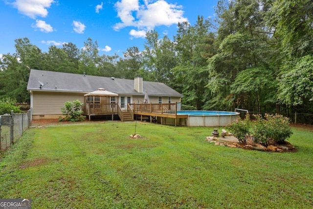 rear view of house featuring a gazebo, a pool side deck, and a yard