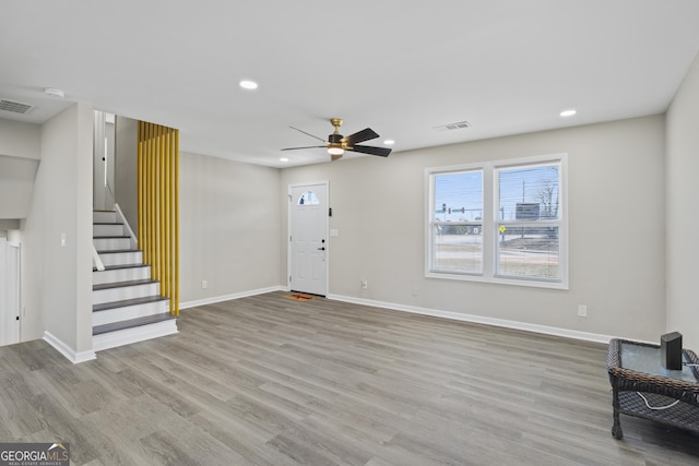 foyer entrance featuring visible vents, baseboards, and wood finished floors