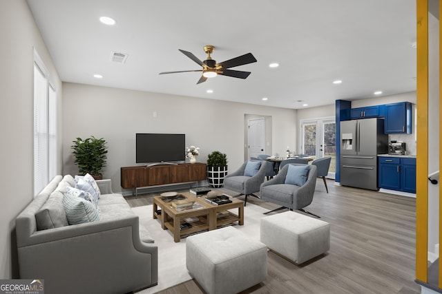 living room with recessed lighting, visible vents, a ceiling fan, and light wood finished floors