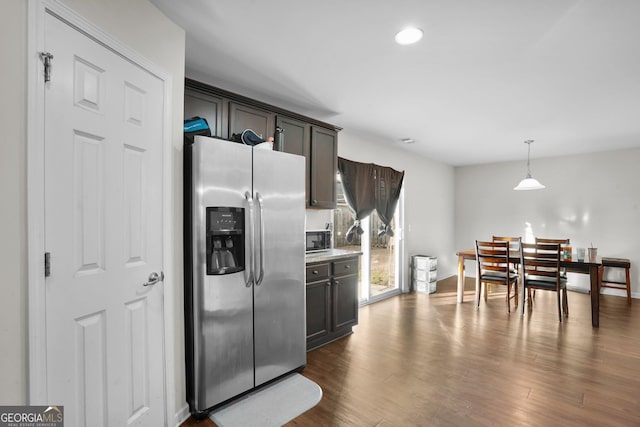 kitchen featuring dark brown cabinetry, stainless steel fridge with ice dispenser, pendant lighting, and dark hardwood / wood-style floors