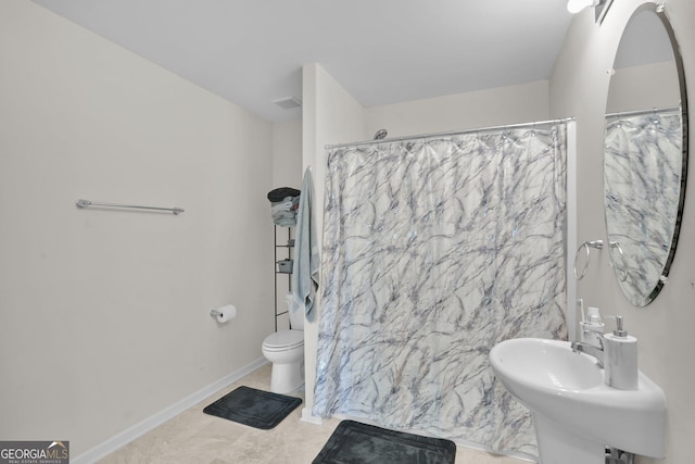 bathroom with tile patterned flooring, sink, curtained shower, and toilet