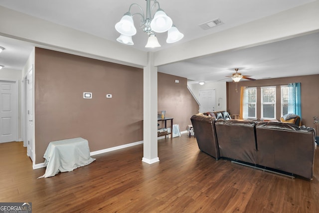 living room with dark wood-type flooring and ceiling fan with notable chandelier