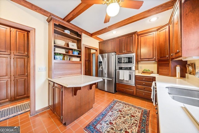 kitchen with light tile patterned flooring, sink, appliances with stainless steel finishes, a kitchen breakfast bar, and beamed ceiling