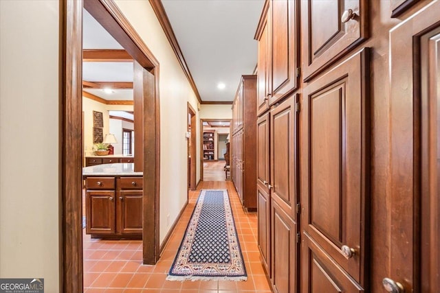 hall with light tile patterned floors and ornamental molding