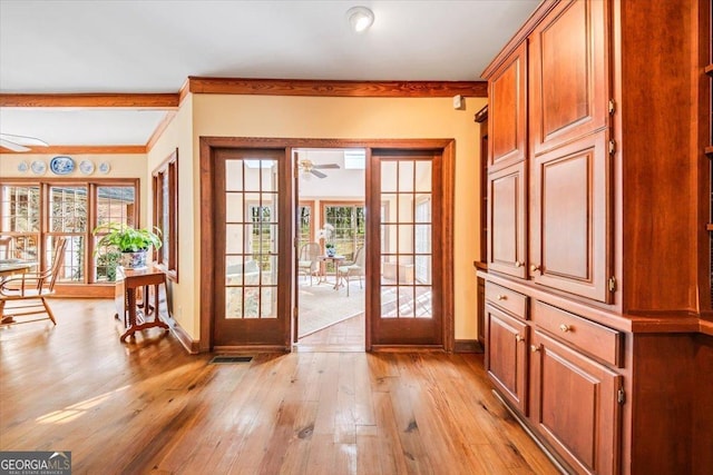 entryway featuring ceiling fan, a wealth of natural light, light wood-type flooring, and french doors