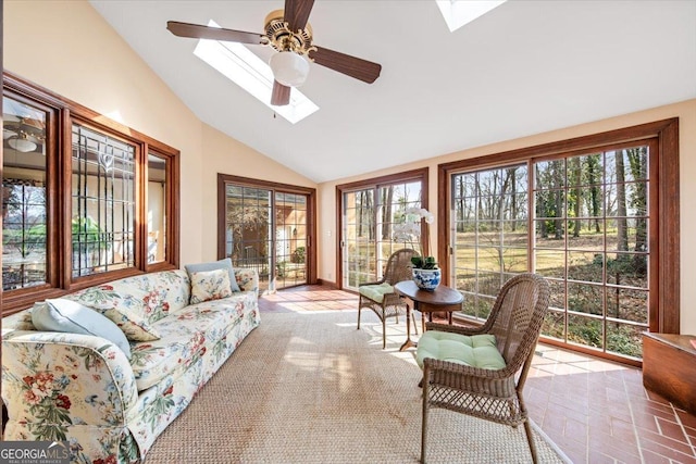 sunroom / solarium featuring a healthy amount of sunlight, vaulted ceiling with skylight, and ceiling fan