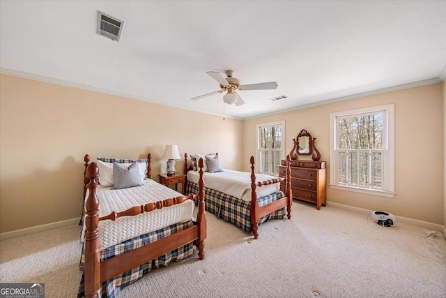 carpeted bedroom with ceiling fan and ornamental molding